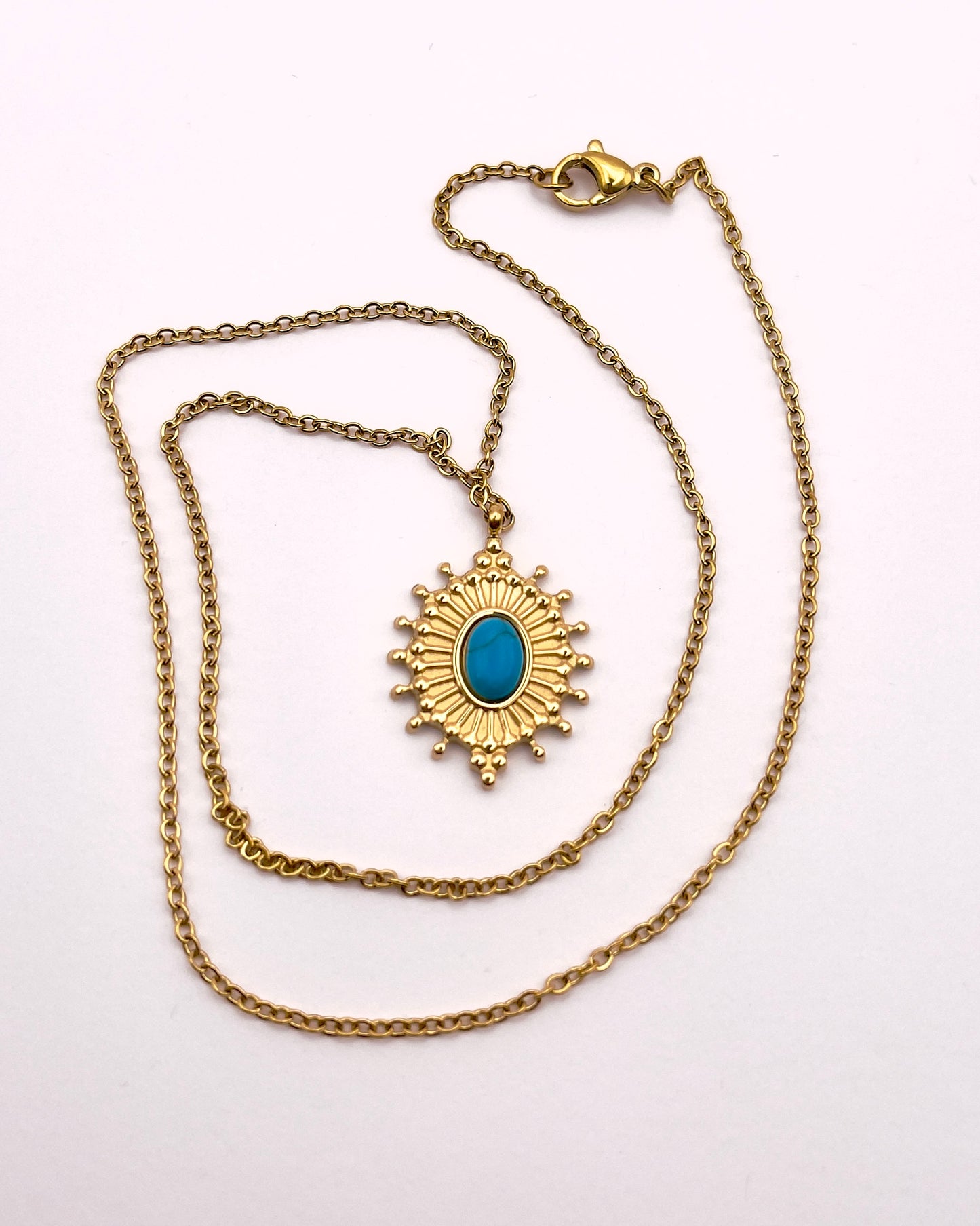 Full front view of Koua, an elegant replica turquoise radial necklace with gold plated chain and artistry.