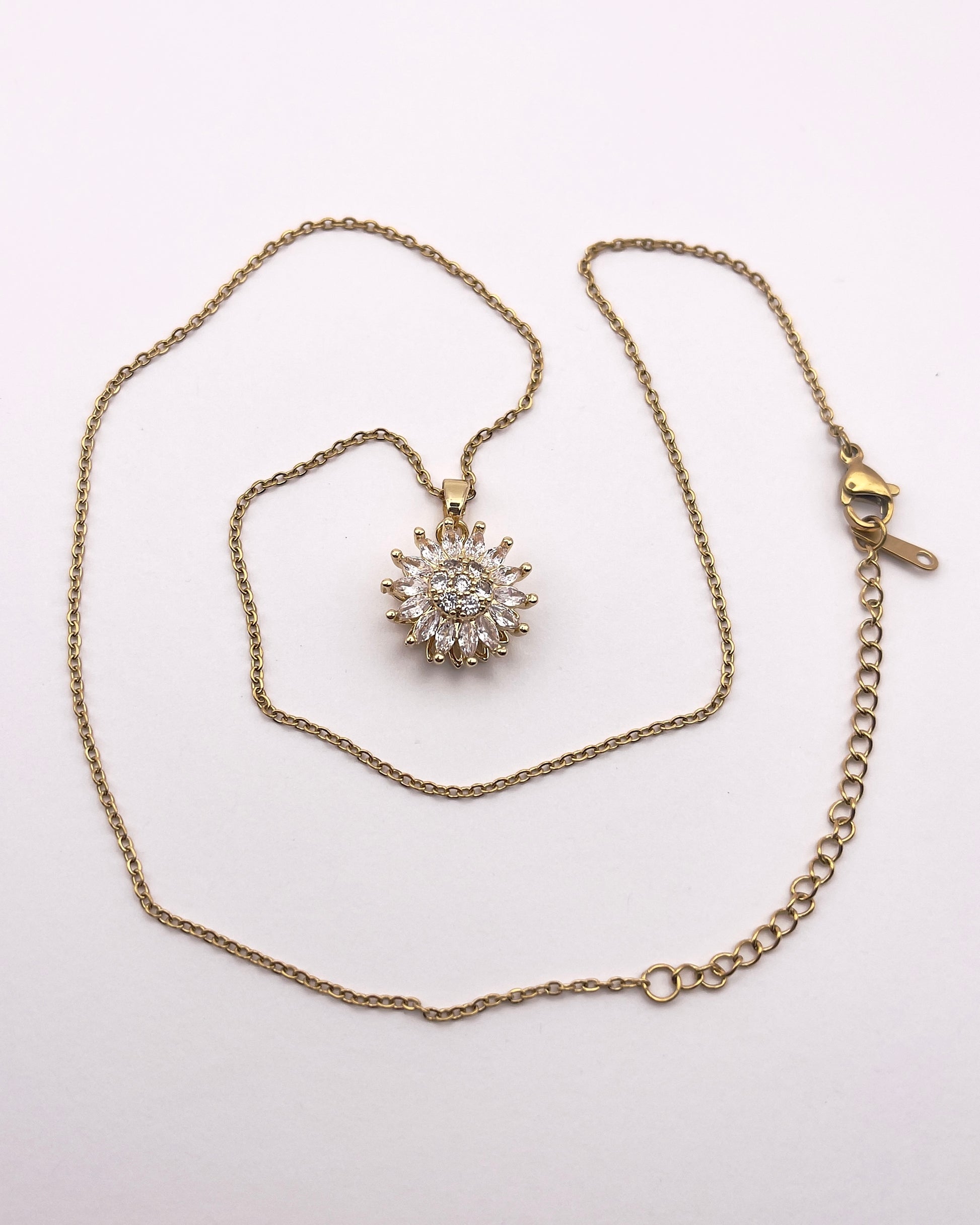 Full front view of Ilio, a stunning gold plated rotating sunflower zircon necklace.