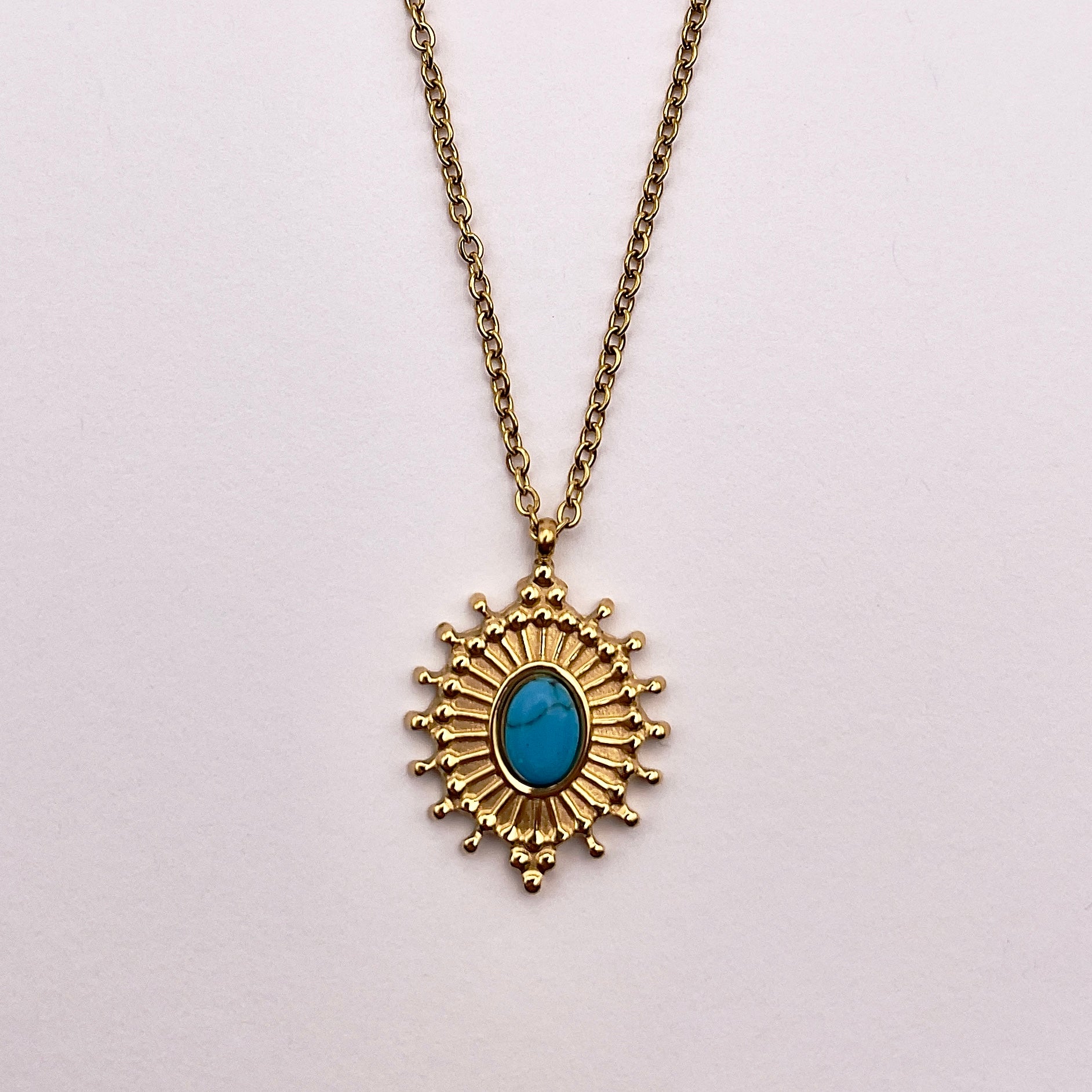 Front view of Koua, an elegant replica turquoise radial necklace with gold plated chain and artistry.