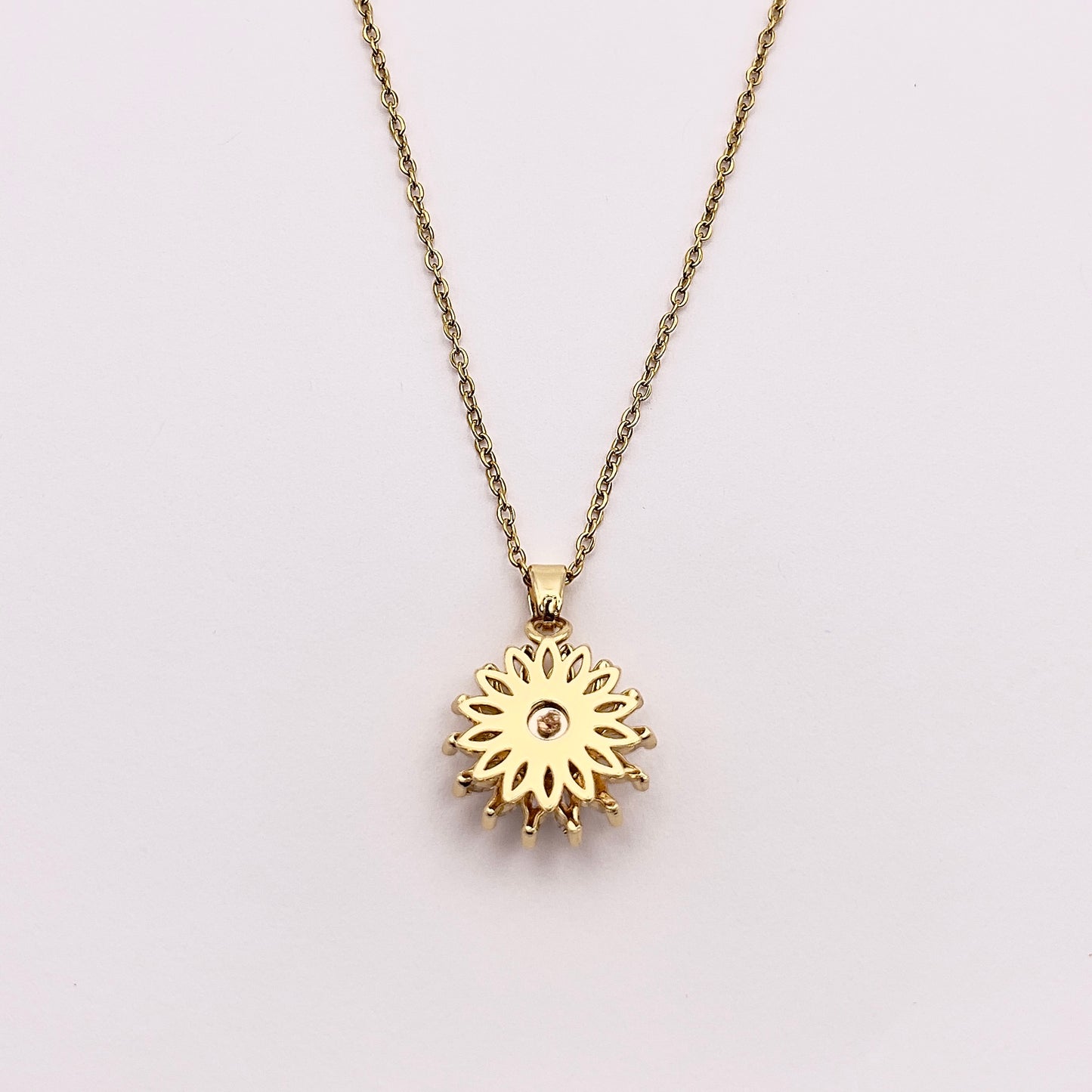 Close up back view of Ilio, a stunning gold plated rotating sunflower zircon necklace.