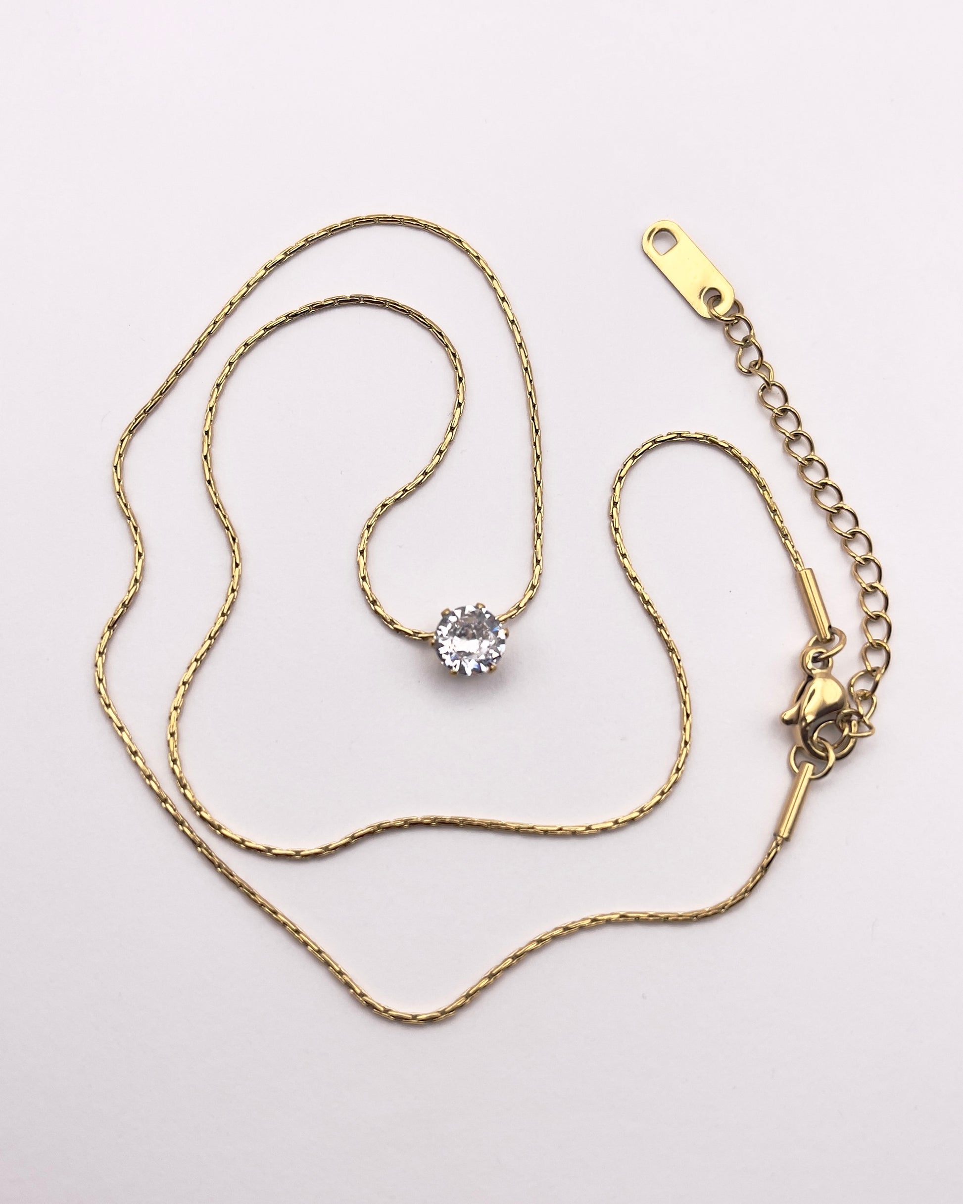 Full view of Lidi, a perfect everyday brilliant refractive zircon with a gold plated link chain.